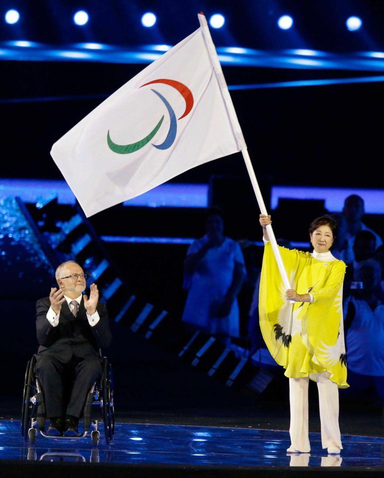 　ＩＰＣのクレーブン会長（左）からパラリンピック旗を手渡された小池都知事（共同）