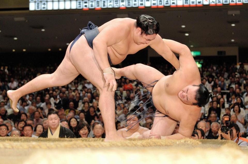 　鶴竜（左）に下手投げで敗れた稀勢の里（撮影・西岡正）