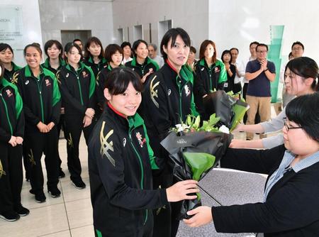 花束を受け取るＪＴマーヴェラスの（手前左から）井上琴絵主将と吉原知子監督＝神戸市、デイリースポーツ本社