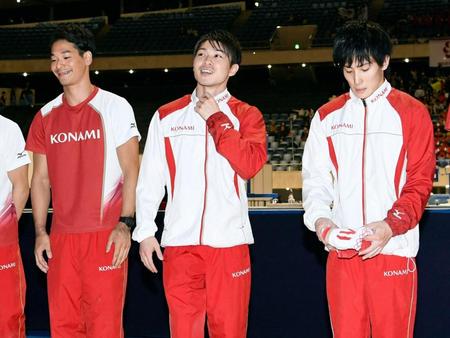 男子決勝の競技終了後、応援席に向かってあいさつする欠場した内村航平（中央）。右は加藤凌平