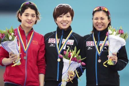 　女子５００メートルで優勝し表彰台で笑顔を見せる小平奈緒（中央）と３位の辻麻希（右）＝ヘーレンフェイン（ゲッティ＝共同）