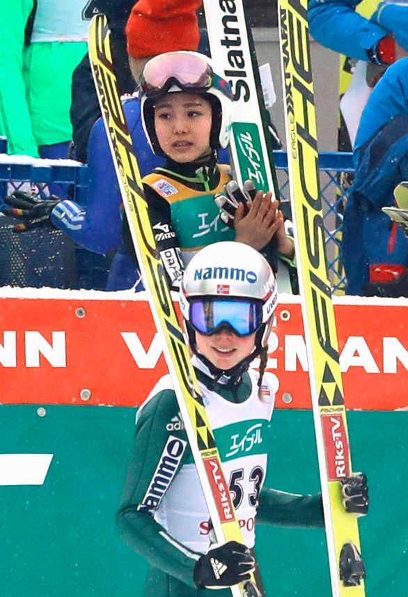 　優勝を決めたマーレン・ルンビー（手前）に拍手を送る高梨沙羅（共同）