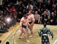 取組後、土俵上ですれ違う稀勢の里（右）と白鵬（前列右から２人目は守屋・横審委員長）＝両国国技館