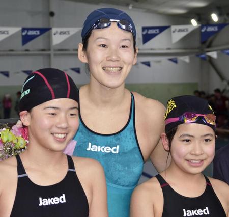 　水泳イベントで子どもたちと記念撮影する金藤理絵（中央）