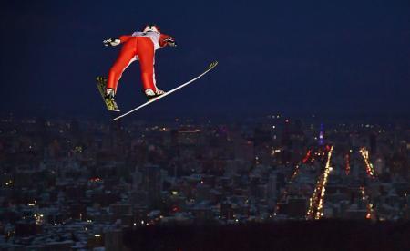 　札幌冬季アジア大会のスキー・ジャンプ男子個人ラージヒルで、夜景に向かって飛躍する中村直幹。金メダルを獲得した＝２４日、札幌市の大倉山