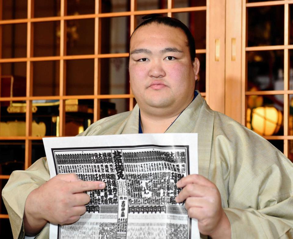 　番付表を持ち、名前を指さす稀勢の里