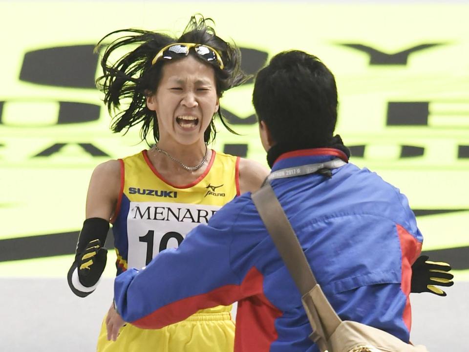 　日本勢トップの２位でゴールし、コーチに迎えられる安藤友香＝ナゴヤドーム