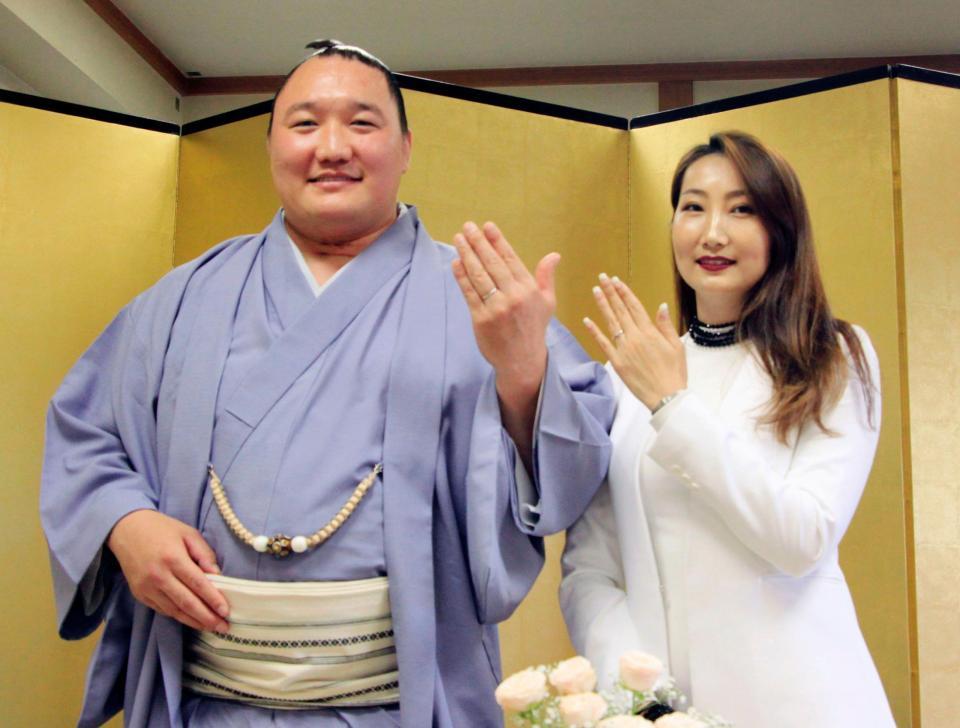 　結婚発表の記者会見で、妻のプレブダシ・ヤンジンラムさんと写真に納まる荒鷲