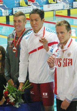 　男子２００メートル平泳ぎで優勝し、表彰台でメダルを掲げる小関也朱篤（中央）＝モナコ（共同）