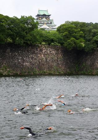 　トライアスロン大会のスイムで、大阪城公園の東外堀を泳ぐ選手たち＝２５日、大阪市