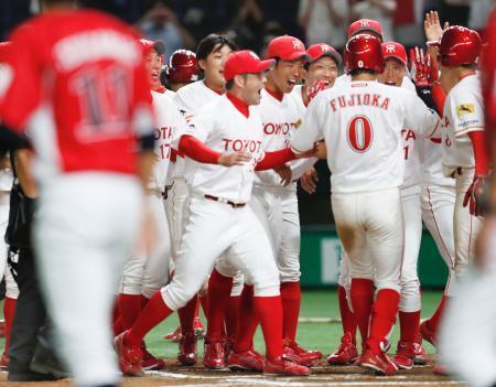 　九州三菱自動車戦で、サヨナラ満塁本塁打を放った藤岡（０）を迎えるトヨタ自動車ナイン＝東京ドーム