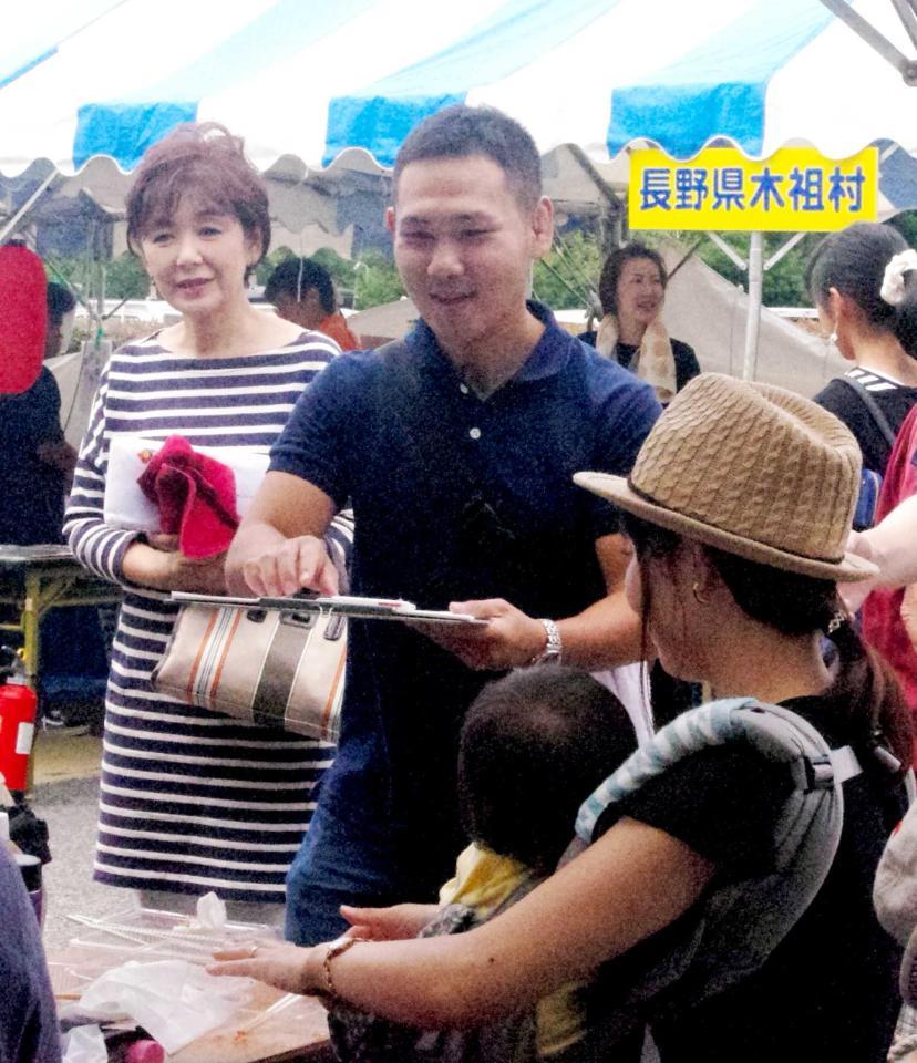 　夏祭りの会場で自ら署名活動を行う高山勝成（中央）