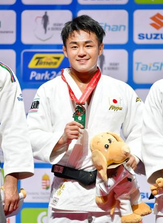 柔道の世界選手権男子73キロ級で優勝し、獲得したメダルを手に笑顔の橋本壮市＝30日、ブダペスト（共同）