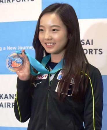 　シニアデビュー戦の優勝メダルを披露するフィギュアスケート女子の本田真凜＝２４日、大阪空港