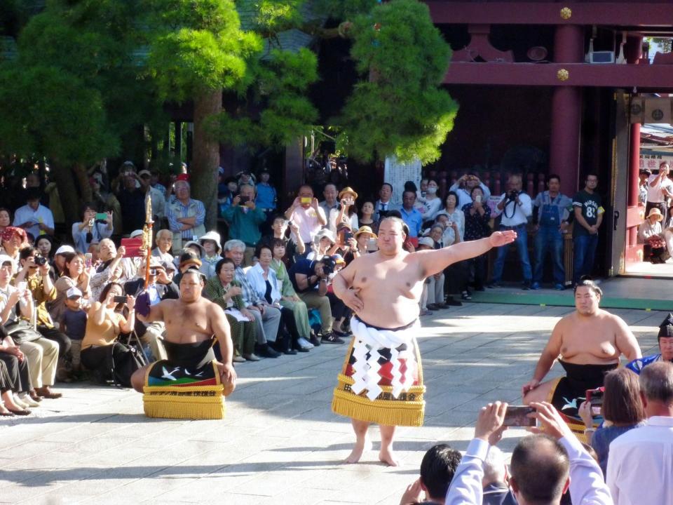 　大勢の観客が見守る前で土俵入りを披露する稀勢の里。左が太刀持ちの松鳳山、右が露払いの輝