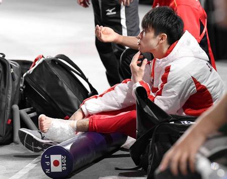 　男子予選で左足首を痛め、床に座って競技を見守る内村航平