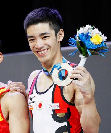 　体操の世界選手権男子個人総合で獲得した銅メダルを手に笑顔の白井健三（共同）