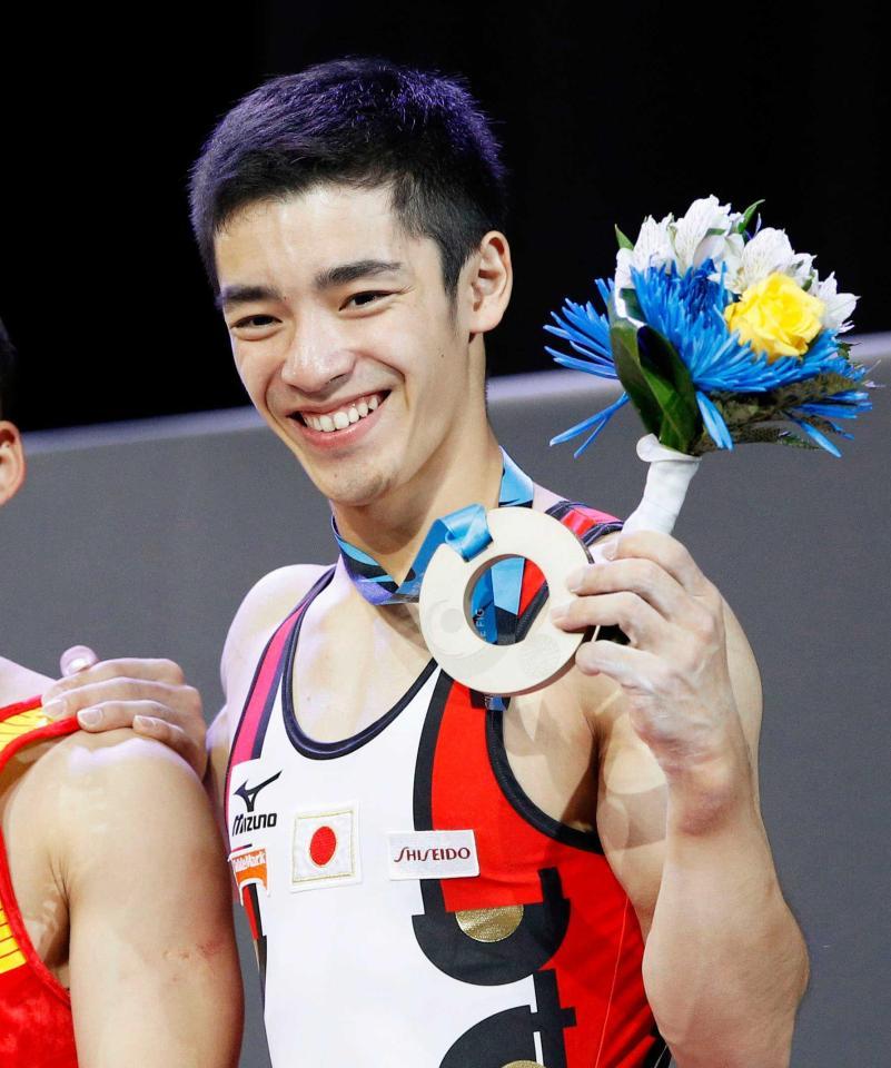 　体操の世界選手権男子個人総合で獲得した銅メダルを手に笑顔の白井健三（共同）