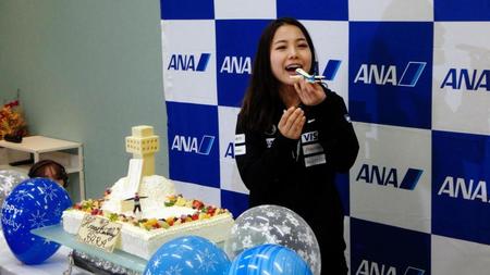 ２１歳の誕生日ケーキの飛行機のデコレーションを手に笑顔の高梨沙羅＝羽田空港