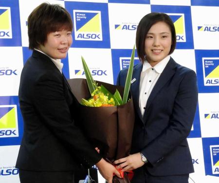 　同僚の梅木真美（左）から花束を贈られる田知本遥