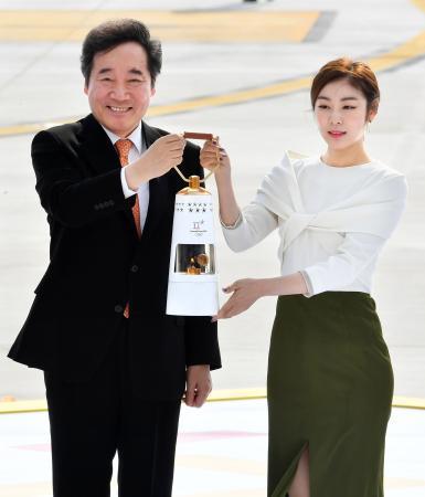 　平昌冬季五輪の聖火を運ぶキム・ヨナさん（右）ら＝１日、韓国の仁川国際空港（共同）