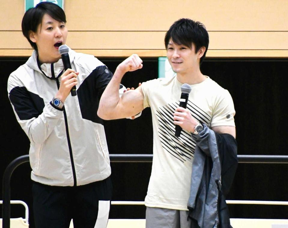 　元競泳日本代表の萩原智子さん（左）の横で筋肉を披露する内村航平