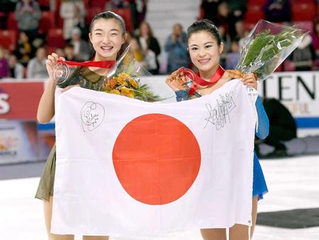 　スケートアメリカの女子で優勝し、日の丸を掲げる宮原知子（右）と２位の坂本花織
