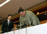 引退会見を終え、深々と頭を下げる日馬富士。左は伊勢ヶ浜親方＝太宰府天満宮境内（撮影・田中太一）