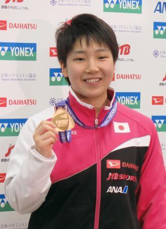 　バドミントンのＳＳファイナルの金メダルを掲げる女子シングルスの山口茜＝１８日、成田空港