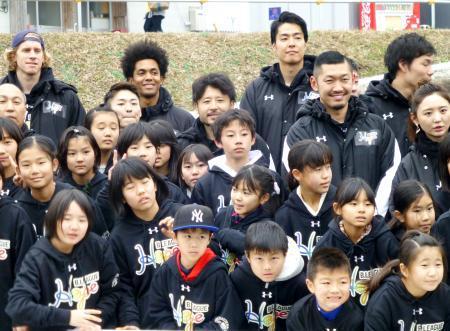 　熊本県益城町の仮設住宅を訪問し、地元の児童らと記念撮影するＢリーグの選手たち＝１３日