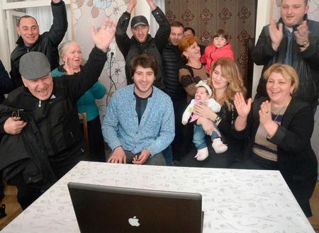 　栃ノ心関の実家で大相撲を観戦し、初優勝に沸く母ヌヌさん（前列右端）と娘のアナスタシアちゃんを抱く妻ニノさん（左隣）ら