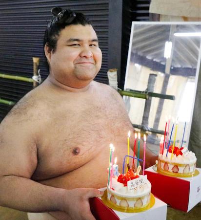 　２８歳の誕生日を迎え、ケーキを手に笑顔の高安（共同）