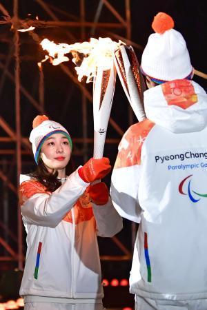 　平昌冬季パラリンピックの聖火リレーで、聖火を引き継ぐキム・ヨナさん＝３日、ソウル（共同）