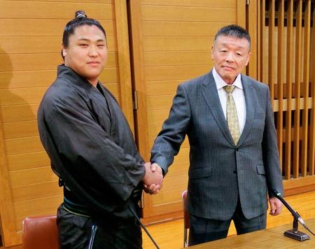 十両昇進を果たし、荒汐親方（右）と握手する若隆景＝28日、エディオンアリーナ大阪