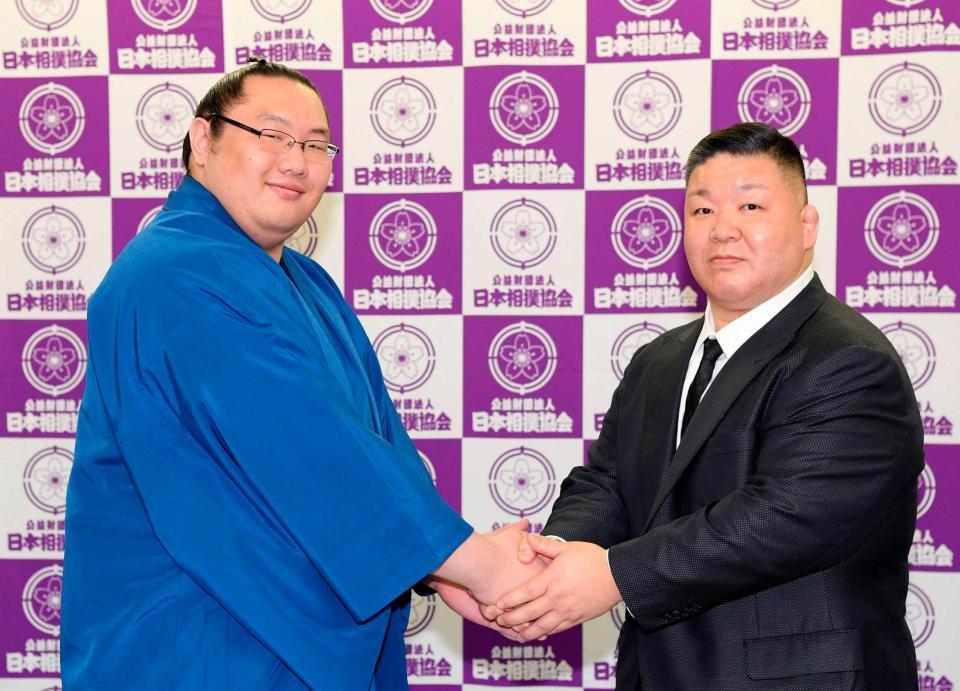 　記者会見で高田川親方（右）と握手を交わす白鷹山