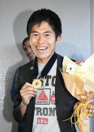 　帰国しメダルを手に笑顔のボストン・マラソンで優勝した川内優輝＝１９日午後、成田空港