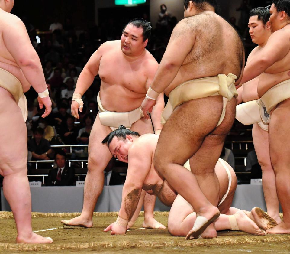 　鶴竜（中央上）に投げられ、土俵にひざまずく稀勢の里（同下）。右から２人目は遠藤