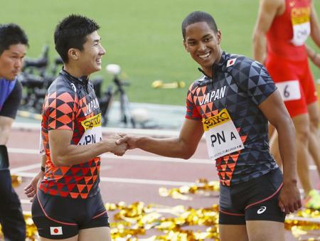　男子４００メートルリレーで優勝し、笑顔で握手する桐生（左）とケンブリッジ＝ヤンマースタジアム長居