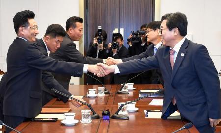 　１８日、板門店で握手する韓国の全忠烈・大韓体育会事務総長（手前右）と北朝鮮の元吉友体育次官（韓国文化体育観光省提供・聯合＝共同）