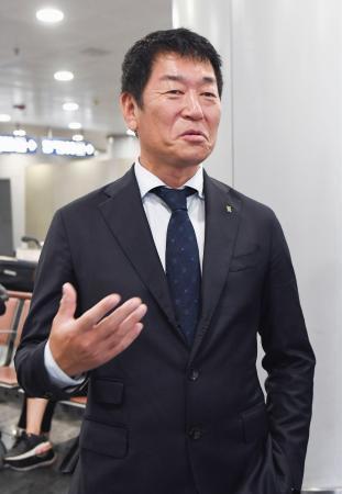 　北朝鮮訪問を前に、北京国際空港で記者団の取材に応じる国際体操連盟の渡辺守成会長＝１２日（共同）