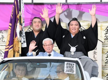 　大相撲名古屋場所で初優勝を果たし、パレードで手を振る関脇御嶽海（右）＝２２日、名古屋市のドルフィンズアリーナ