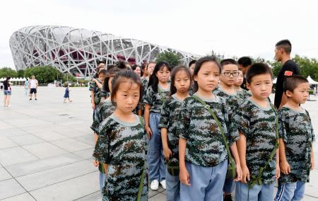 　８日、北京市の国家体育場（左奥）を訪れた子どもたち（共同）