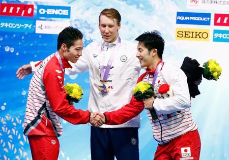 　男子４００メートル個人メドレーの表彰式で握手する２位の萩野公介（左）と３位の瀬戸大也。中央は優勝したチェース・ケイリシュ（共同）