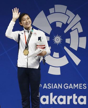 　女子１００メートルバタフライで優勝し、表彰式で手を振る池江璃花子。今大会四つ目の金メダルを獲得した＝ジャカルタ（共同）