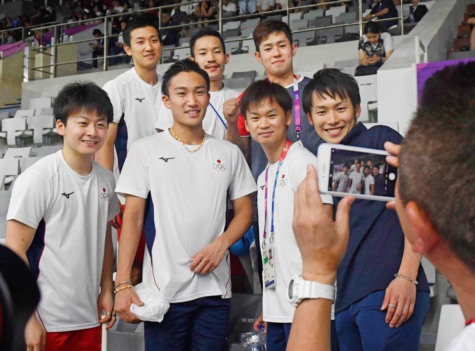 　男子団体で準決勝進出を決め、笑顔で記念写真に納まる桃田賢斗（前列左から２人目）ら日本チーム（共同）