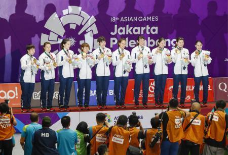 　ジャカルタ・アジア大会のバドミントン女子団体で優勝し、表彰式で金メダルを手に笑顔の日本チーム＝２２日、ジャカルタ（共同）