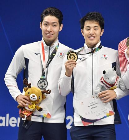 　男子４００メートル個人メドレーで優勝し、笑顔でメダルを手にする瀬戸大也。左は２位の萩野公介＝22日、ジャカルタ（共同）