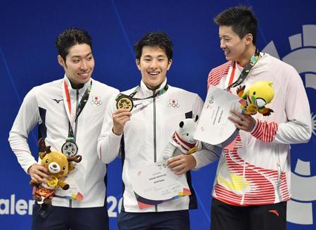 　男子４００メートル個人メドレーで優勝し、笑顔でメダルを手にする瀬戸大也（中央）。左は２位の萩野公介＝22日、ジャカルタ（共同）