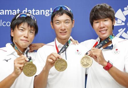 　銅メダルを手に笑顔の男子シングルスカル荒川（中央）と、男子かじなしペアの大塚（左）、高野組＝パレンバン（共同）