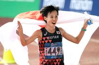 女子マラソンで２位となり、日の丸を広げて喜ぶ野上恵子＝ジャカルタ（共同）